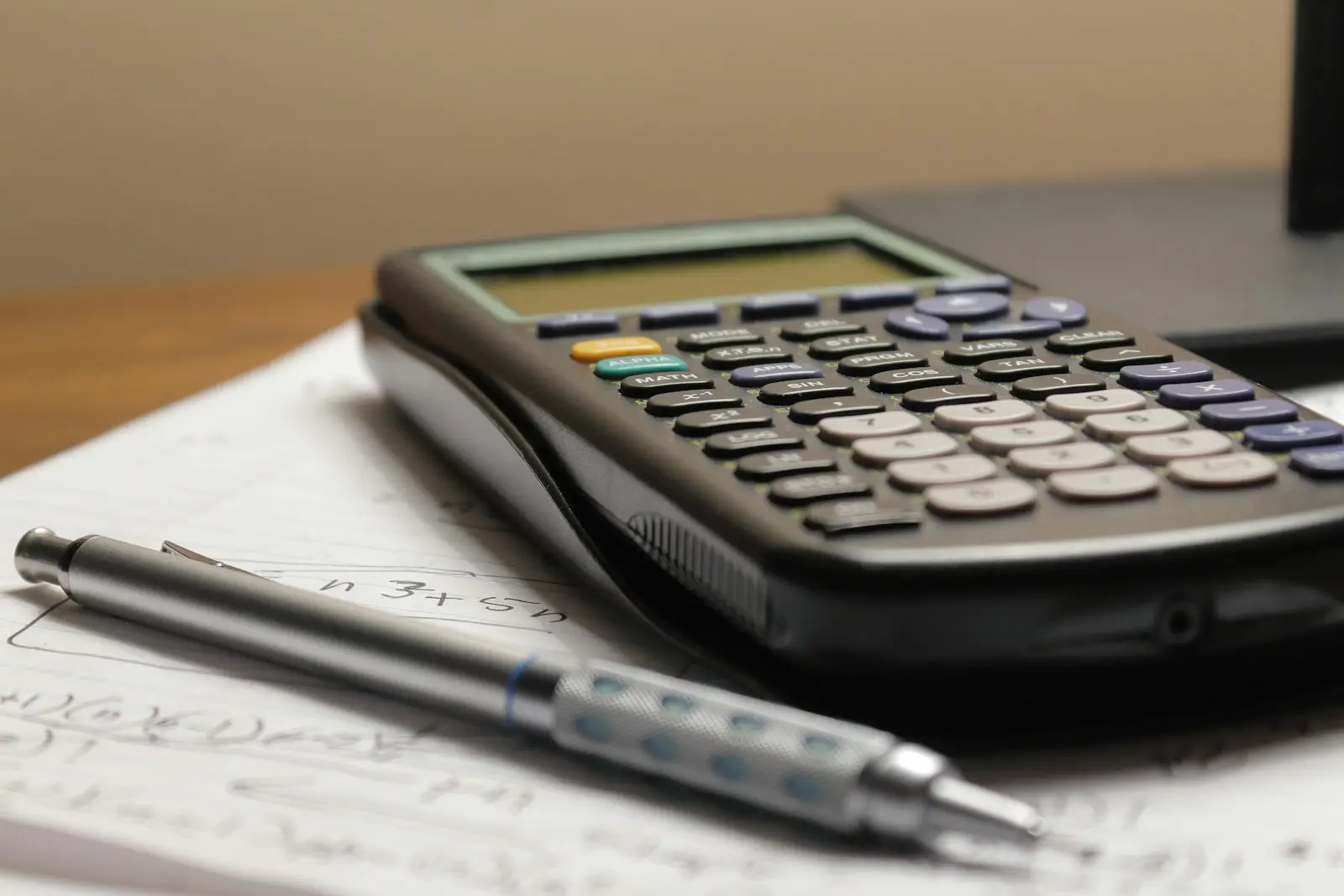 Calculadora y portaminas sobre una hoja con cálculos